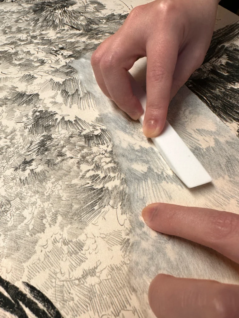 Travail manuel sur une œuvre graphique en noir et blanc de Stéphanie Mansy.